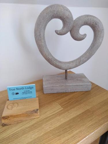 a metal sculpture on top of a wooden table at True North Lodge - A cosy wee highland Getaway in Spean Bridge