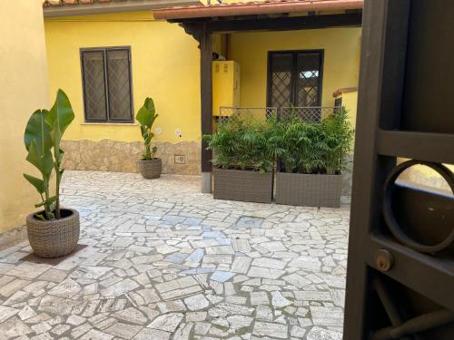 a house with potted plants in front of a building at Corte Prini Fiumicino in Fiumicino