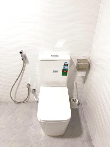 a white toilet in a bathroom with a shower at Lahiru Airport Villa in Andiambalama