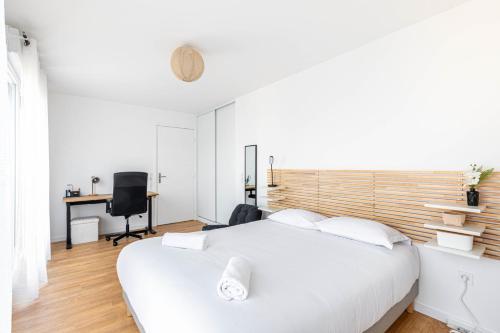une chambre avec un lit blanc et un bureau dans l'établissement GuestReady - Bright and Stylish Stay near Paris, à Saint-Ouen