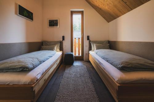 two twin beds in a room with a window at Schmiedgut Bad Aussee in Bad Aussee