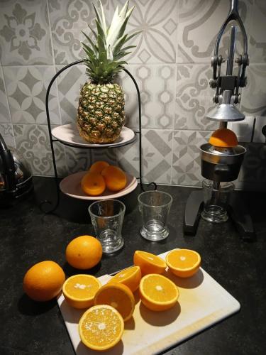 a bunch of oranges on a cutting board with a pineapple at Mas Tulipe de Soie in Bevons