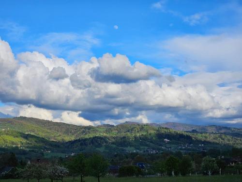 a sky filled with clouds over a green mountain at Ubytování Zaolší in Vendryně
