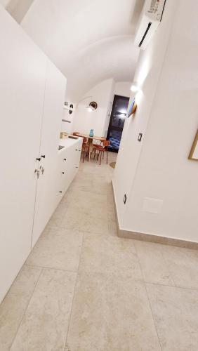 a kitchen with white cabinets and a tile floor at B&B La Casa Di Bianca in Manfredonia