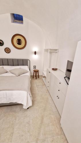 a white bedroom with a bed and a desk at B&B La Casa Di Bianca in Manfredonia