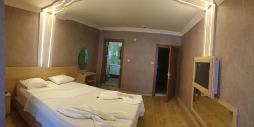 a bedroom with a white bed and a television at City Light Otel in Istanbul