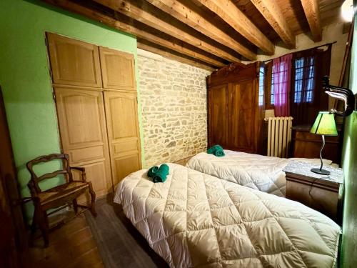 une chambre avec deux lits et une chaise dans l'établissement Mas Le Clos de Teillan 6 chambres 3 SDB, Piscine, Sauna, Bain à remous, à Aimargues