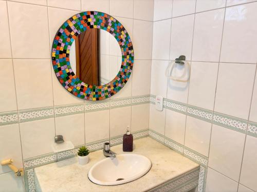 a bathroom with a sink and a mirror at Terra do Sol Pousada e Hostel in Porto Seguro