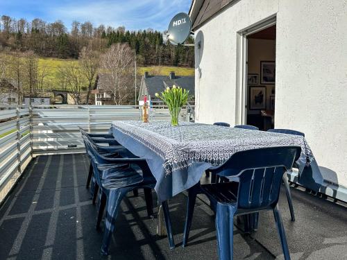 ein blauer Tisch und Stühle auf einer Terrasse in der Unterkunft Silbach Panorama Lodge in Winterberg