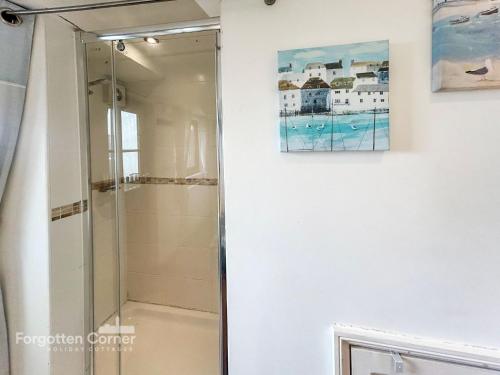 a shower in a bathroom with a painting on the wall at The Wash House in Torpoint