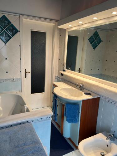 a bathroom with a sink and a tub and a mirror at MaMà - Ma Maison d'Hotes in Vigliano Biellese