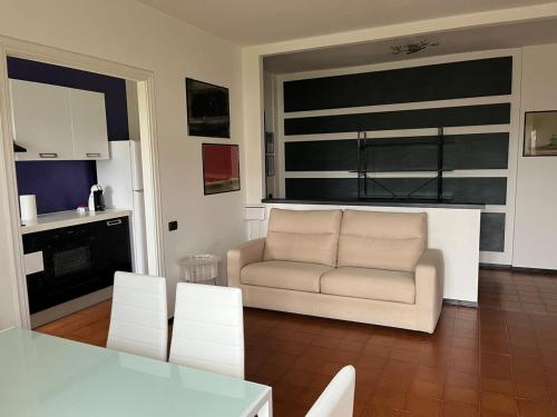 a living room with a couch and a table and chairs at MaMà - Ma Maison d'Hotes in Vigliano Biellese