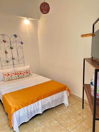 a bedroom with a bed with an orange blanket at Encanto 3 in Santa Rosa de Cabal