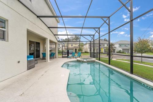a swimming pool with a patio and a house at SUPER LARGE - 12BD 12BAs - MANY ENSUITEs SLEEPs 30 in Kissimmee