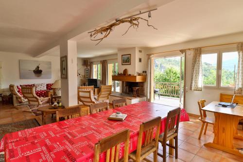 une salle à manger avec une table et des chaises rouges dans l'établissement La ressource - Chalet entier, à Villars-Colmars
