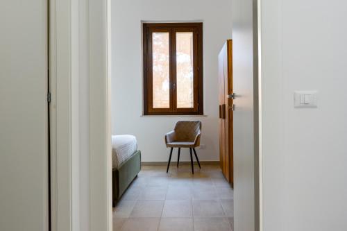 a room with a bed and a chair and a window at Il Giardino del Tempio in Agrigento