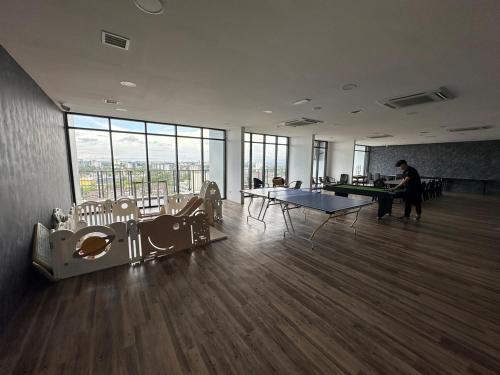 a room with ping pong tables in a building with windows at Podium Premium 4 Bed Room in Kuching