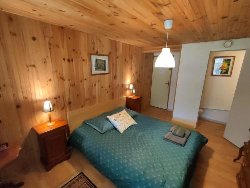 une chambre avec un lit dans une pièce aux murs en bois dans l'établissement La ressource - Chalet entier, à Villars-Colmars