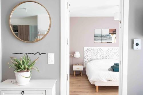 une chambre avec un lit et un miroir au mur dans l'établissement Little Murmur - Détente absolue entre lac, golf et océan à Hossegor, à Soorts-Hossegor