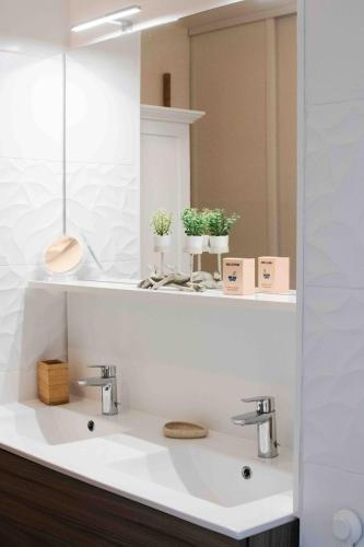 une salle de bain avec un lavabo blanc et un miroir dans l'établissement Little Murmur - Détente absolue entre lac, golf et océan à Hossegor, à Soorts-Hossegor
