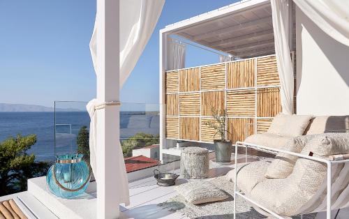 a balcony with a bed and a view of the ocean at Canal Suites Kythnos in Kanala