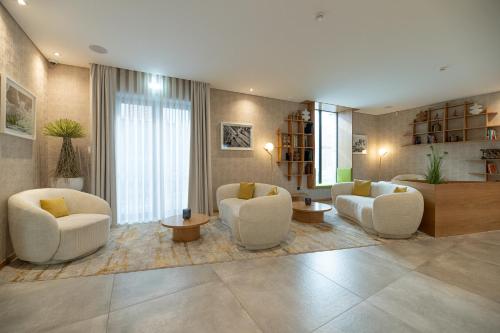 a large living room with white chairs and tables at Favaios Aldeia Resort - Casa das Padeiras in Favaios