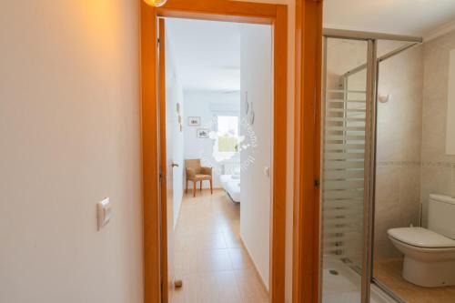 a bathroom with a toilet and a glass door at CostaBlancaDreams Bungalow Gran Sol in Calpe in Calpe