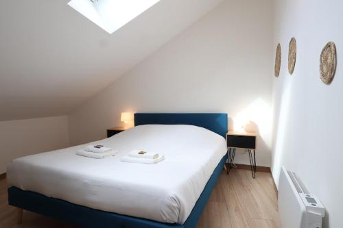 une chambre avec un lit blanc avec deux serviettes dessus dans l'établissement La perle de champagne 4 pers au coeur des vignes, à Jonchery-sur-Vesle