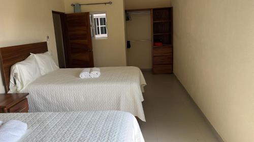 a bedroom with two beds with towels on them at Bungalows El Cielo in San Patricio Melaque