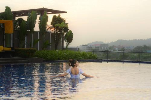 a woman is standing in a swimming pool at Radisson Blu Hotel Guwahati in Guwahati