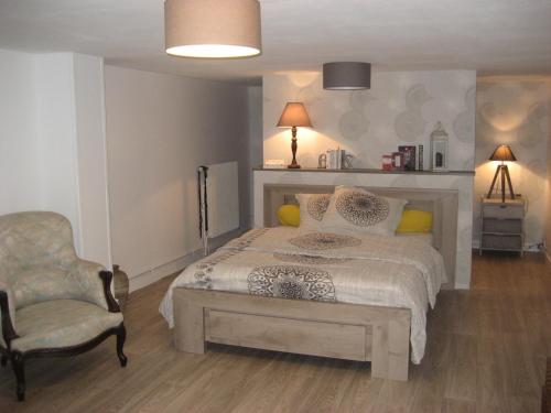 une chambre avec un lit et une chaise dans l'établissement Agréable & Lumineux, à La Rochelle