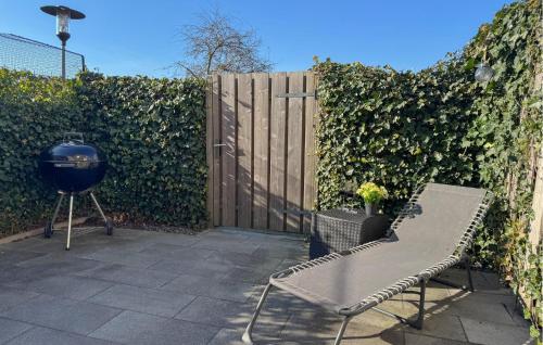 a grill and a bench next to a fence at 2 Bedroom Cozy Home In Bruinisse in Bruinisse