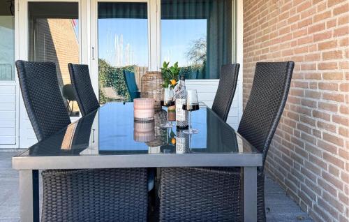 a glass table with chairs on a patio at 2 Bedroom Cozy Home In Bruinisse in Bruinisse