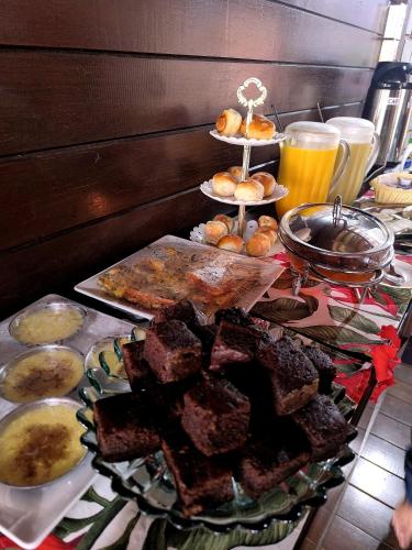 een tafel met een buffet van eten en drinken bij Pousada Capim Açu in Fernando de Noronha
