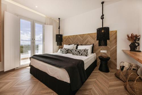 a bedroom with a large bed and a large window at Hidden Gem - 2Br Sea View Villas - Plaka Beach Naxos in Naxos Chora