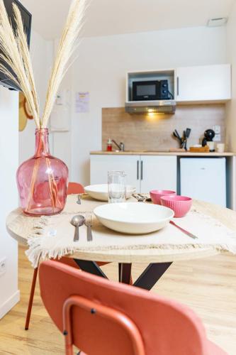 - une table avec deux chaises et un vase dans l'établissement Studio Séduisant 2pers wifi gare, à Saint-Quentin