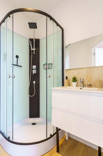 une douche en verre dans une salle de bain avec un lavabo dans l'établissement Studio Séduisant 2pers wifi gare, à Saint-Quentin