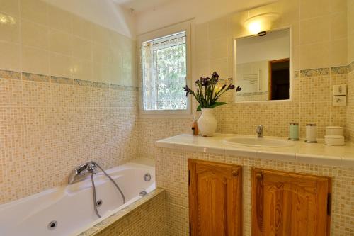une salle de bain avec une baignoire, un lavabo et un miroir dans l'établissement La ressource - Chalet entier, à Villars-Colmars