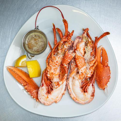 a plate of shrimp and carrots and a bowl of dipping sauce at Ashes Seafood Restaurant Accommodation in Dingle