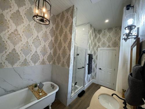 a bathroom with a tub and a sink and a bath tub at Woodside Farm Country Inn in Sooke