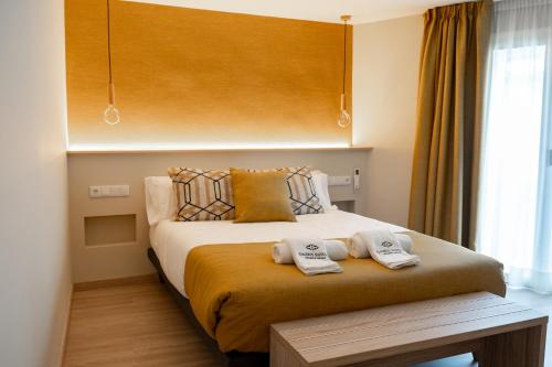 a bedroom with a bed with two towels on it at Qazris Suites in Cáceres