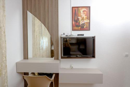 a living room with a television and a mirror at Apartments Oliva in Utjeha