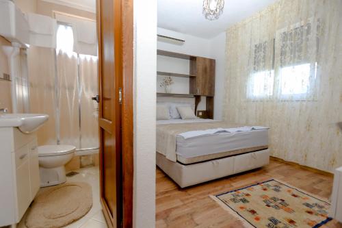 a bedroom with a bed and a toilet and a sink at Apartments Oliva in Utjeha