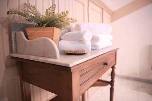a pile of towels sitting on top of a table at Patio des Rêves - Charme au cœur du Gers in Aujan-Mournède