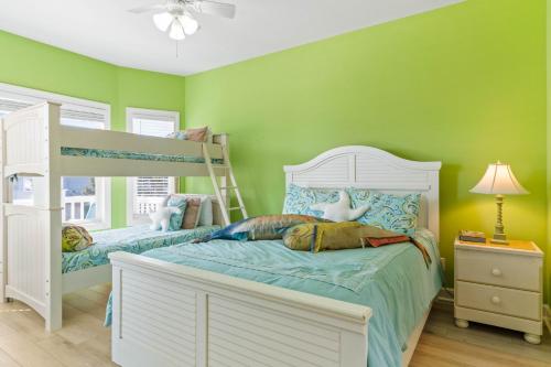 a bedroom with two bunk beds and green walls at Cherry Bomb Private heated Pool, Elevator in Ocean Isle Beach