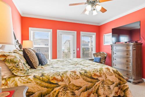 a bedroom with orange walls and a bed and a dresser at Cherry Bomb Private heated Pool, Elevator in Ocean Isle Beach