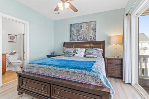 a bedroom with a bed and a ceiling fan at Cherry Bomb Private heated Pool, Elevator in Ocean Isle Beach
