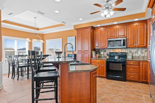 a kitchen with wooden cabinets and a table with chairs at Cherry Bomb Private heated Pool, Elevator in Ocean Isle Beach