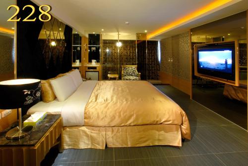 a hotel room with a large bed and a television at 薇風情汽車旅館 - 自由館 in Kaohsiung