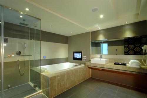 a bathroom with a shower and a tub and a sink at 薇風情汽車旅館 - 自由館 in Kaohsiung